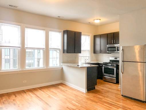A kitchen with wooden floors and stainless steel appliances.