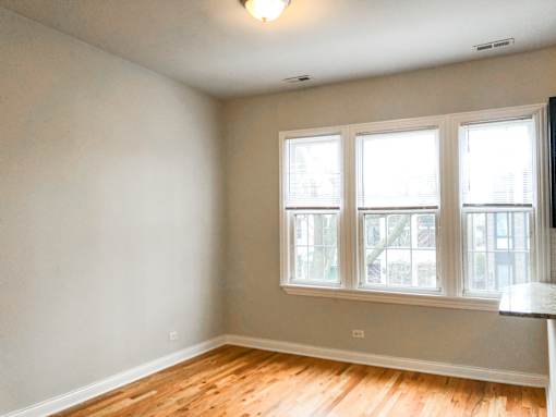 A room with a window and wooden floors.
