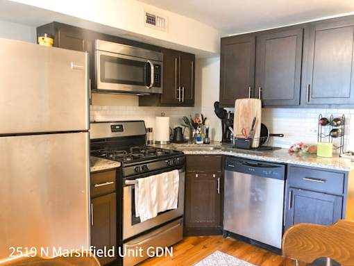 A kitchen with a refrigerator, microwave, oven, and dishwasher.