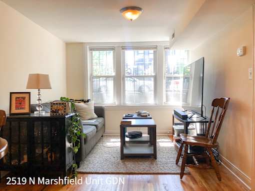 A living room with a couch, chair, and television.