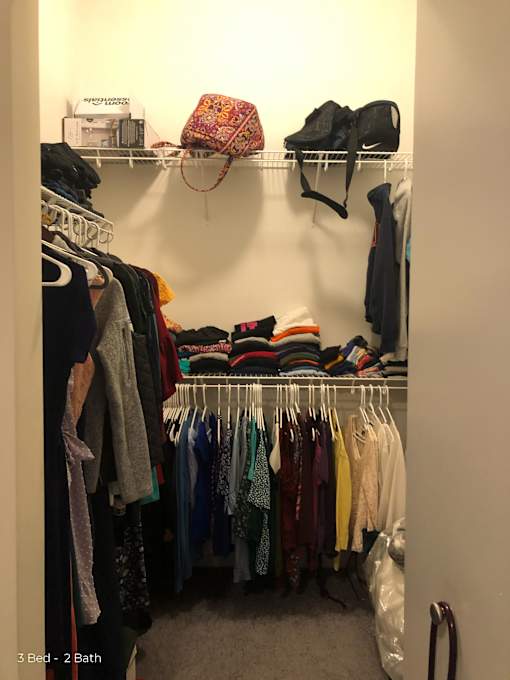 a closet filled with clothes and a rack of clothes on the wall