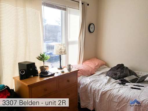 a bedroom with a bed and a dresser and a window