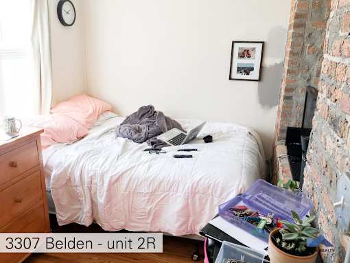a bedroom with a bed with a laptop on it