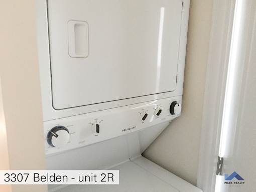 two washers and a dryer in a white room
