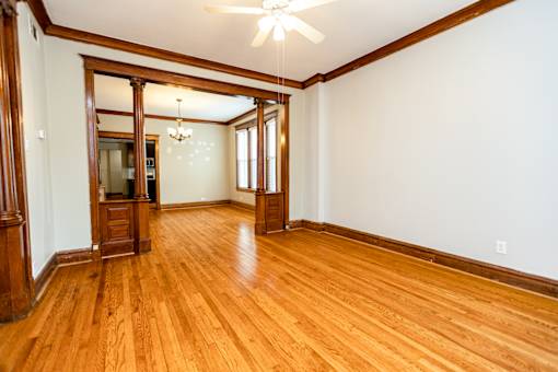 A room with wooden floors and a ceiling fan.