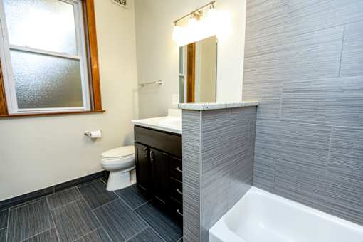 A bathroom with a toilet, sink, and tub.
