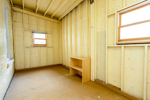 A room with wooden walls and a window is shown.