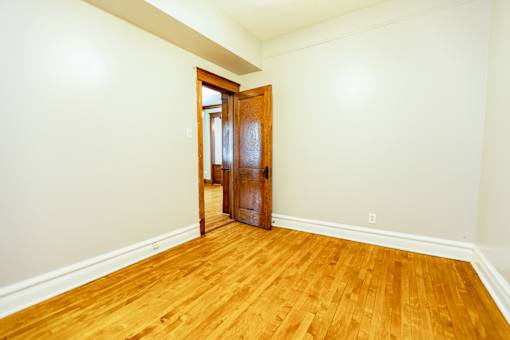 A room with a wooden floor and a wooden door.