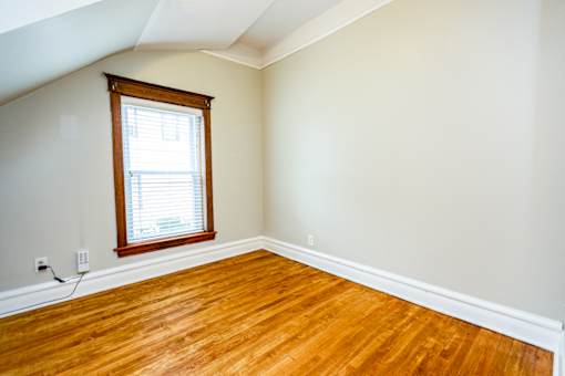 A room with a window and wooden floors.