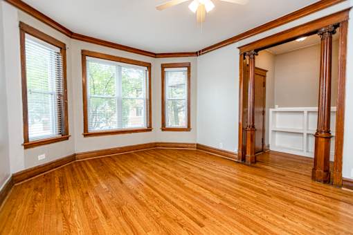 A room with wooden floors and a ceiling fan.