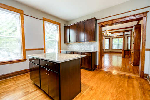 A kitchen with wooden floors and a marble counter top.