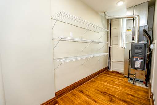 A room with a wood floor and a wall-mounted heating system.