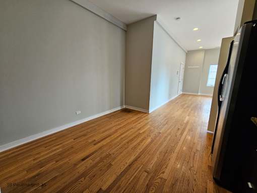 a living room and hallway with wood floors and grey walls
