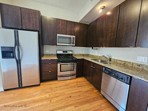 a kitchen with wooden cabinets and stainless steel appliances