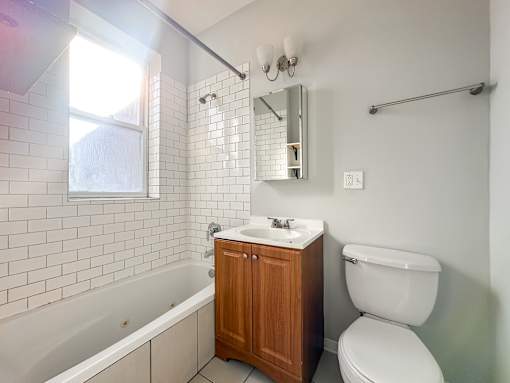 A white toilet sits next to a sink in a bathroom.
