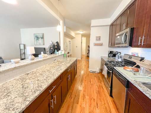 a large kitchen with granite counter tops and wood floors