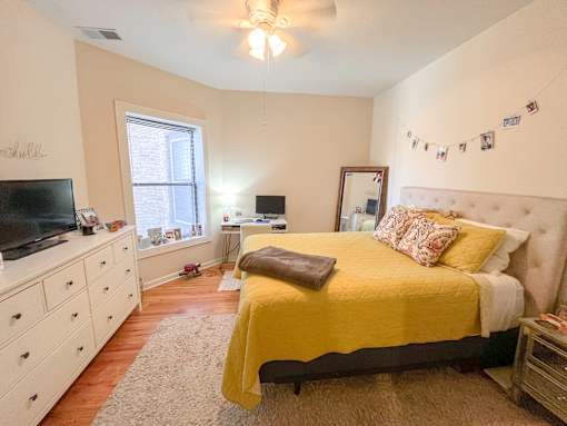 a bedroom with a bed and a dresser and a tv