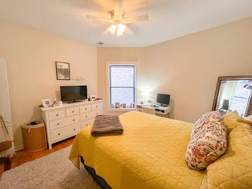 a bedroom with a yellow bed and a ceiling fan