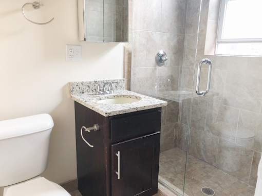 a small bathroom with a shower sink and toilet