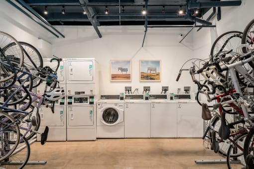 a laundry room with washing machines and bicycles hanging on the wall