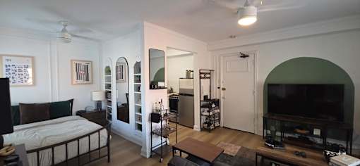A bedroom with a bed, dresser, and mirror.
