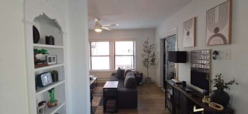 A living room with a couch, a television, and a fireplace.