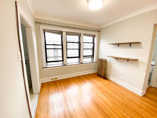 A room with a window and a radiator on the wall.