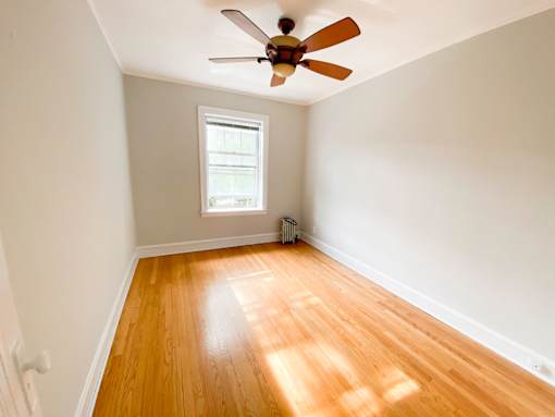 A room with a ceiling fan and a window.