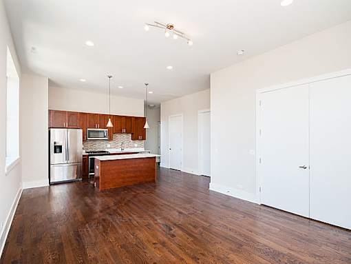 A kitchen with wooden floors and white walls.