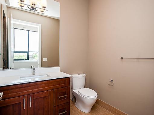 A white toilet sits in a bathroom next to a sink.