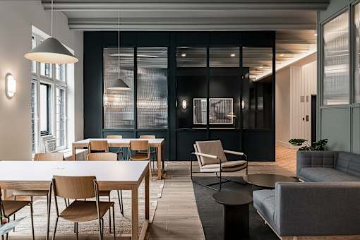A modern dining room with a long table and chairs.