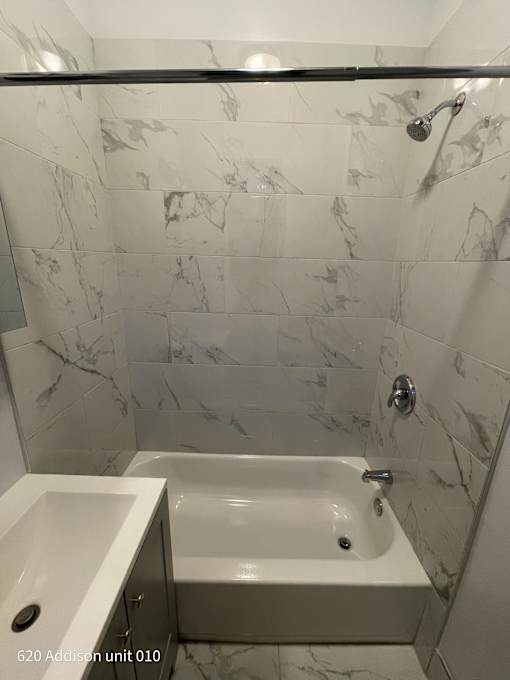 a white bathroom with a tub and a sink