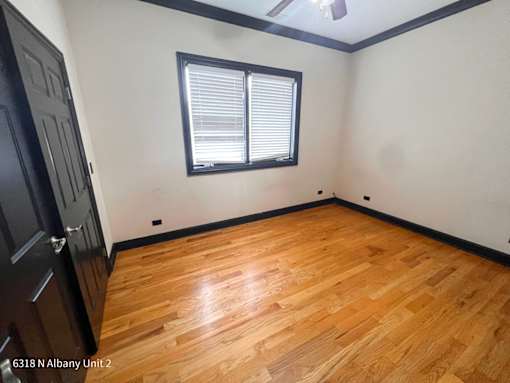 the living room of a house with wood floors and a window