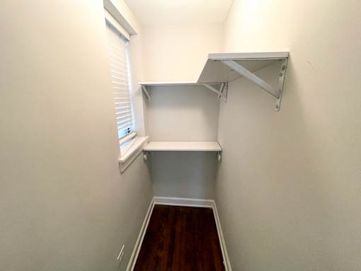 A white shelf is mounted on a white wall.