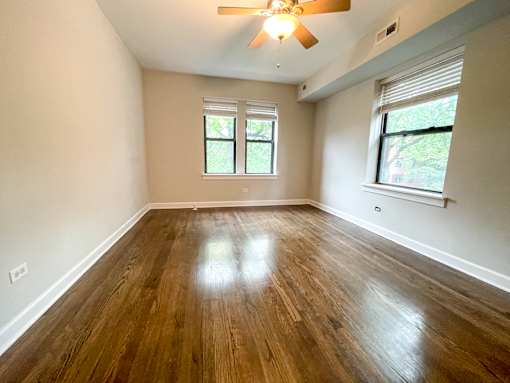 A room with wooden floors and a ceiling fan.