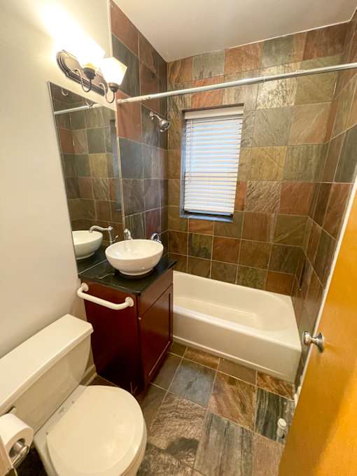 A bathroom with a toilet, sink, and tub.