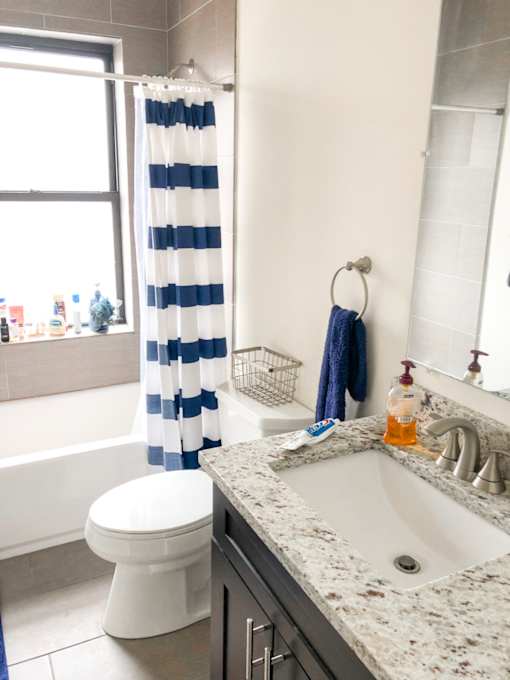 a white bathroom with a blue and white striped shower curtain