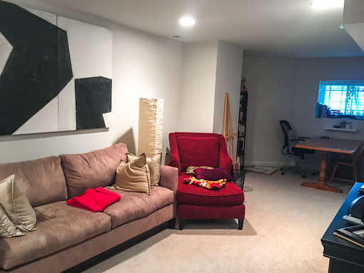 A living room with a brown couch and a red chair.