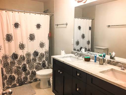 A bathroom with a toilet, sink, and shower curtain.