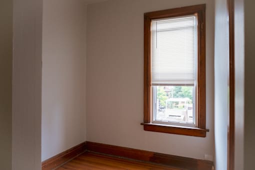 A room with a window and wooden floors.