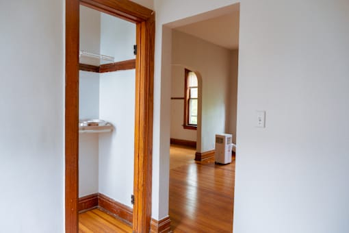 A white wall with a wooden door and a window.