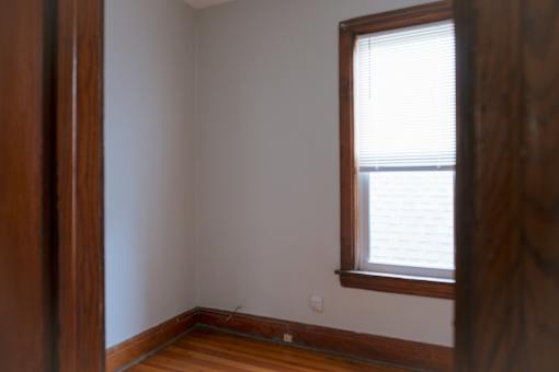 A room with a window and wooden floors.