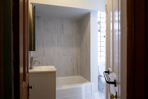 A bathroom with a white tub and sink.