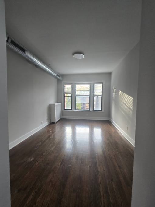 A room with wooden floors and a window.