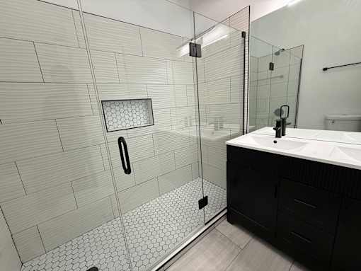 A bathroom with a walk-in shower and a sink.