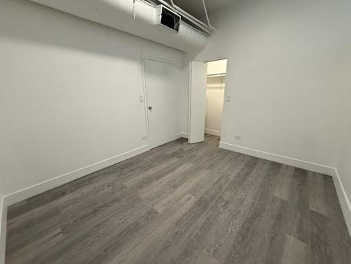 A room with a grey floor and a white door.