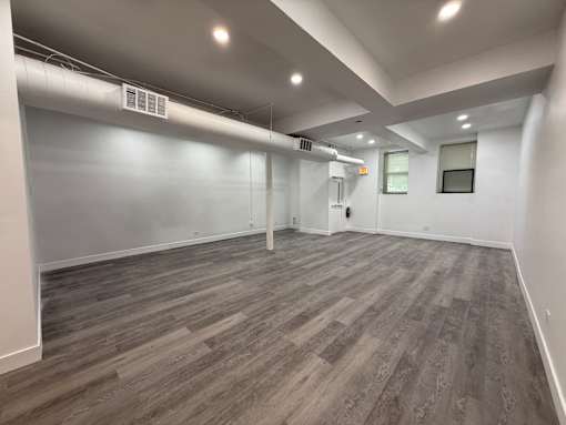 A room with wooden flooring and white walls.