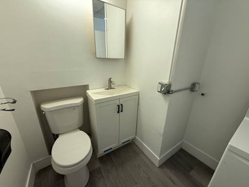 A white toilet and sink in a small bathroom.