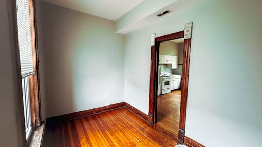 A room with a wooden floor and a mirror on the wall.