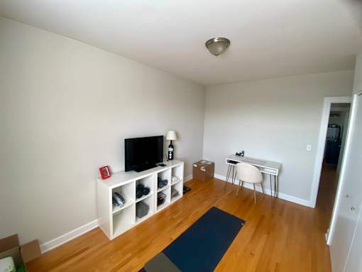 A room with a television, a desk, and a chair.